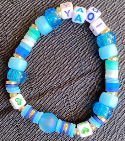 Yaoi bracelet Bracelet in inspired by the colours of the mlm flag, with the word yaoi on it.